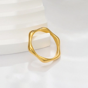 Macro shot of minimalist 18k gold wave ring with high-polish texture and wavy design