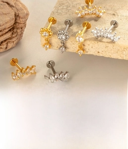 Detail of titanium flat back stud earrings with star and crown zircon designs