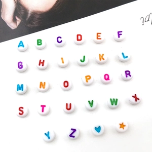 Macro view of 7mm white acrylic alphabet beads with colorful A-Z letters and symbols