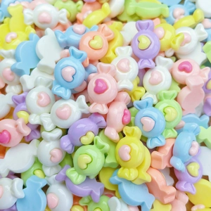 Close-up of colorful resin candy charms with heart details for DIY nail art and crafts