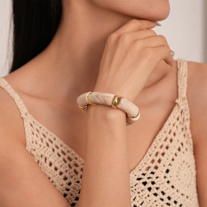 Detail of vintage acrylic bamboo-style stretch bracelet with marble texture and gold rings