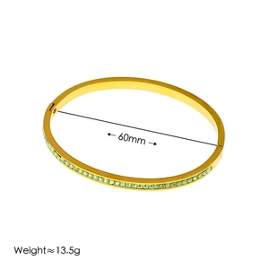 Gold plated stainless steel hinged bracelet with green zircon inlay and 60mm diameter