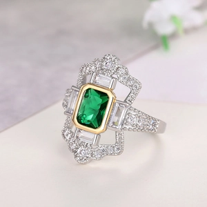 Vista macro de un anillo de lujo con gema verde cuadrada y diamantes en oro y plata