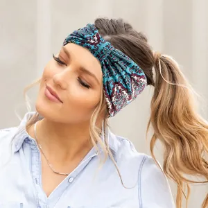 Detail of wide paisley print elastic headband with bohemian twist knot on model