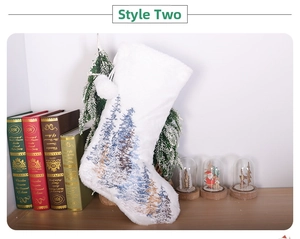 Close-up of plush white Christmas stocking with embroidered pine forest and soft pom-poms