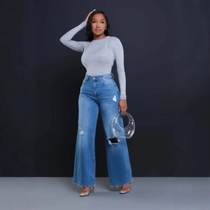 Full view of high waist wide leg ripped jeans with grey knit top and clear bag