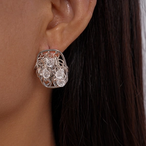 Gros plan de boucles d'oreilles carrées évidées avec cristaux sur un modèle féminin