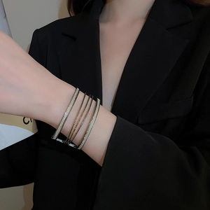 Detailed view of layered minimalist metal bracelets with sparkling pavé on female model