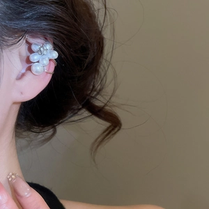 Vue rapprochée d'un clip d'oreille floral avec perles blanches et zircon sur oreille