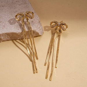 Macro view of 18K gold plated bow earrings with zircon stones and long tassel chains