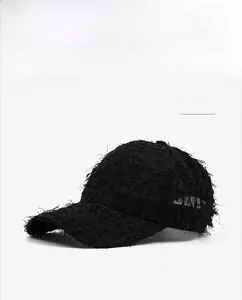 Detail view of black distressed baseball cap featuring fringe texture and curved brim