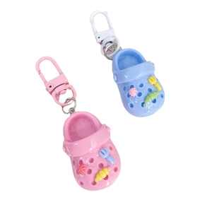 Pink and blue mini clog shoe keychains with cute cartoon charms on white background