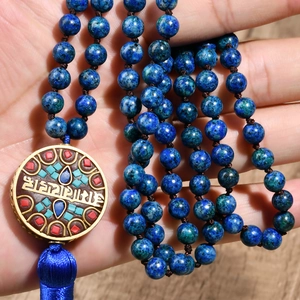 Dettaglio della collana etnica con perline, pendente in pietra blu e nappina di seta