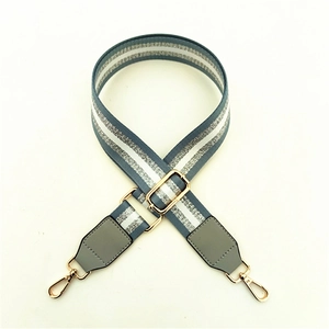 Detail of adjustable blue and silver glitter wide shoulder strap with gold metal buckles
