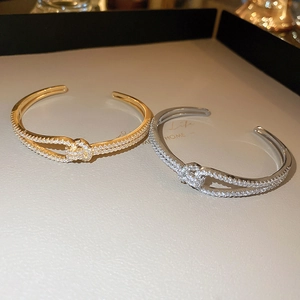 Detailopname van gouden en zilveren kruisarmbanden met micro-gezette zirkonia