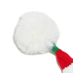 Detailed view of soft white faux fur pompom and festive red-green knit pattern on Christmas hat