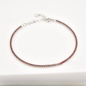 Detailed macro of S925 sterling silver tennis bracelet with round red zircon stones