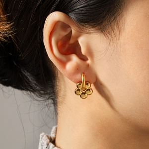 Polished 18k gold plated stainless steel flower earrings shown on a model