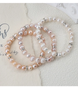 Dettaglio dei bracciali di perle d'acqua dolce rosa, bianche e champagne con zirconi