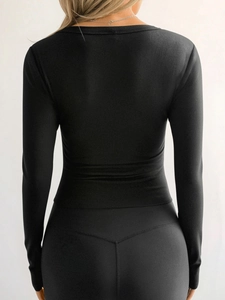 Back view of a black long sleeve ribbed tight-fitting sports top for women on a model