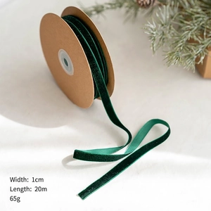 Détail d'un ruban de velours vert foncé de 1cm sur bobine pour emballage de Noël
