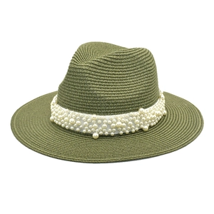 Close-up of olive green straw fedora hat featuring white ribbon and elegant pearl accents
