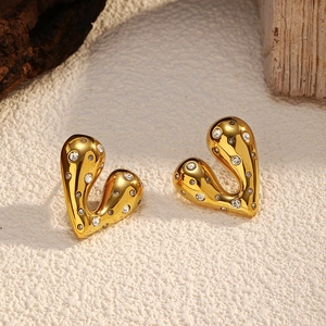 Macro detail of 18k gold plated heart stud earrings with white cubic zirconia stones