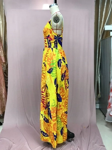 Detail of yellow tropical leaf print and flowy fabric on a bohemian floor-length dress