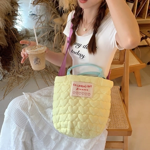 Sac à main matelassé à cœur avec poignées bleues et bandoulière violette au café