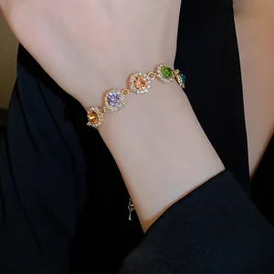 Bracelet strass coloré avec pierres multicolores et monture dorée sur le poignet