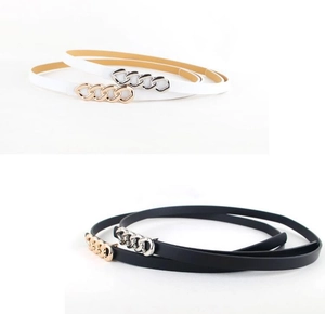 Detail view of thin waist belts in black and white with gold and silver chain buckles