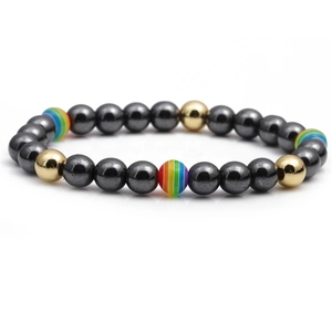 Detailed macro view of gunmetal and gold beaded bracelet with rainbow stripe accents