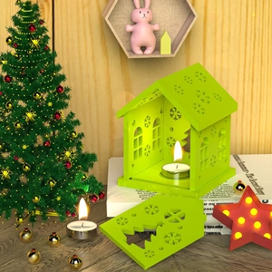 Detalle del portavelas casa de Navidad verde claro con copos de nieve y velas de té