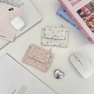 Détail de porte-cartes en tissu à motifs floraux rose et crème avec boutons en cœur