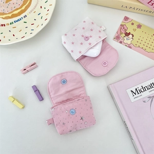 Flat lay of pink and white fabric earphone cases with star patterns and snap closure