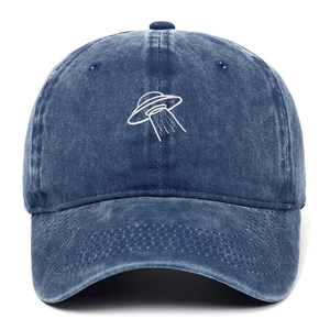 Detailed embroidery of a white UFO on a washed vintage blue denim baseball cap