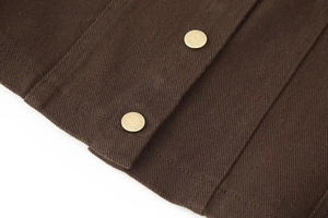 Detailansicht der dunkelbraunen Twill-Struktur und der goldenen Vintage-Metallknöpfe