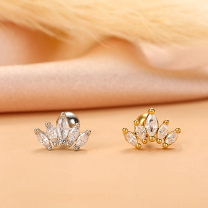 Close-up of gold and silver crown stud earrings with marquise-cut cubic zirconia