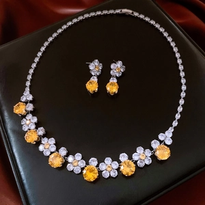 Detail of silver vintage necklace and earrings set with zircon flowers on black leather