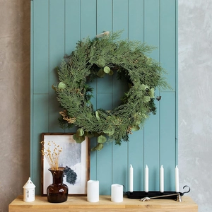 Ghirlanda di pino artificiale verde per decorazione natalizia su parete in legno rustico