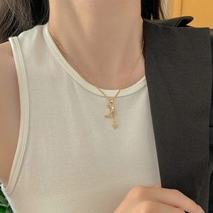Detail of gold moon pendant with square zircon and star tassel on female model