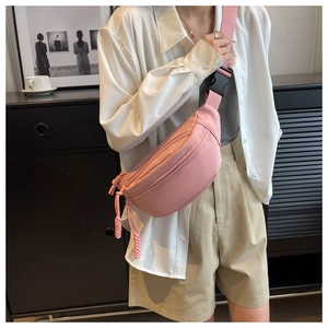 Detail of pink canvas waist bag with braided zipper pull and adjustable strap