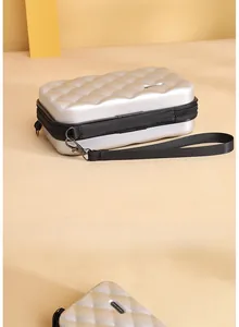 Silver quilted hardshell mini crossbody bag with zipper closure and wrist strap
