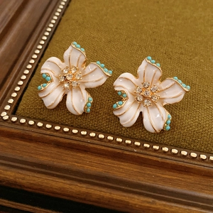 Vue détaillée de boucles d'oreilles vintage fleurs en émail blanc et perles turquoise