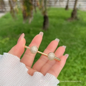 Dettaglio del bracciale aperto placcato oro 18K con design a spirale e sfere di zirconi