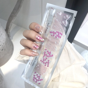 Detail of pink glitter and heart pattern nail polish stickers in transparent packaging
