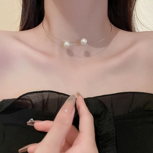 Gros plan d'un tour de cou argenté à double couche orné de deux perles blanches