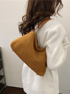 Sac hobo chic en daim camel avec une silhouette minimaliste pour un look tendance