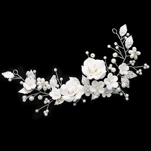 Detailed bridal hair vine with white roses, silver leaves, and pearls on black background