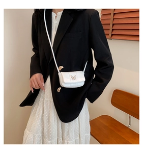 Gros plan d'un mini sac bandoulière blanc matelassé avec fermoir papillon doré chic